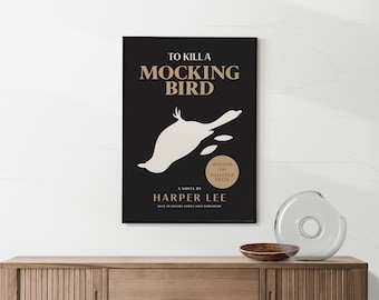 Könnte beinhalten: Gerahmtes Poster mit dem Titel "TO KILL A MOCKINGBIRD" in goldener Schrift auf schwarzem Hintergrund. Eine weiße Vogelillustration befindet sich unter dem Titel. Der Name des Autors, Harper Lee, ist darunter abgebildet.
