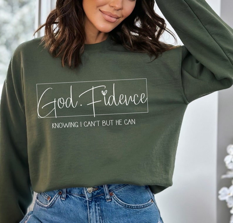 以下が含まれることがあります： 白い文字で「God. Fidence」と「Knowing I can't but He can」と書かれた緑色のスウェットシャツです。