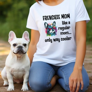 以下が含まれることがあります： 「Frenchie Mom like a regular mom... only way cooler」という文字と、サングラスをかけたフレンチブルドッグの漫画が描かれた白いTシャツ。白いフレンチブルドッグがTシャツを着た人の隣に座っている。