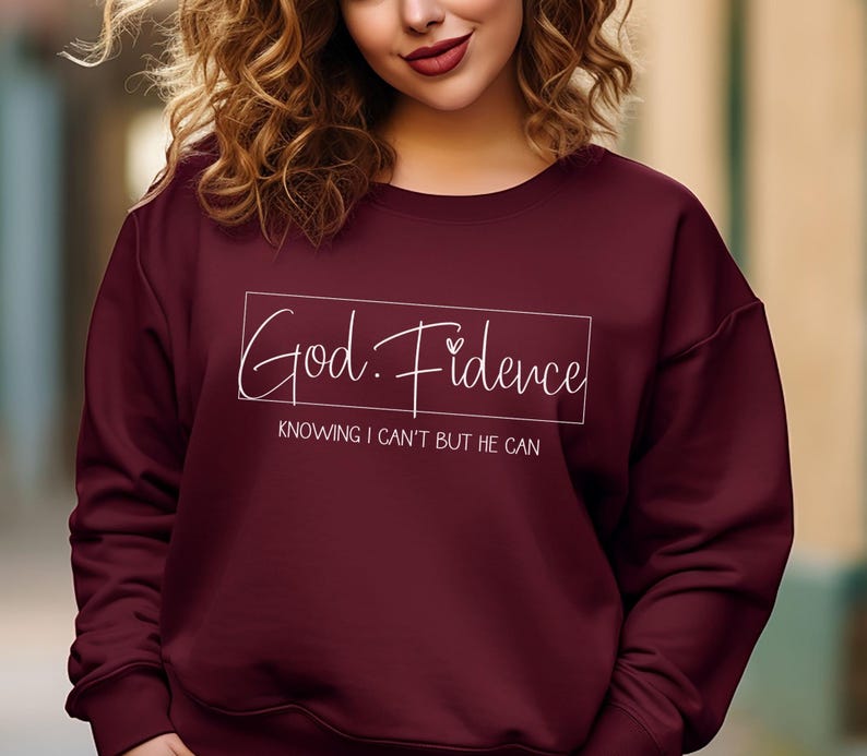 以下が含まれることがあります： ワインレッドのトレーナーに、白い文字で「God. Fidence」と「Knowing I can't but He can.」と書かれています