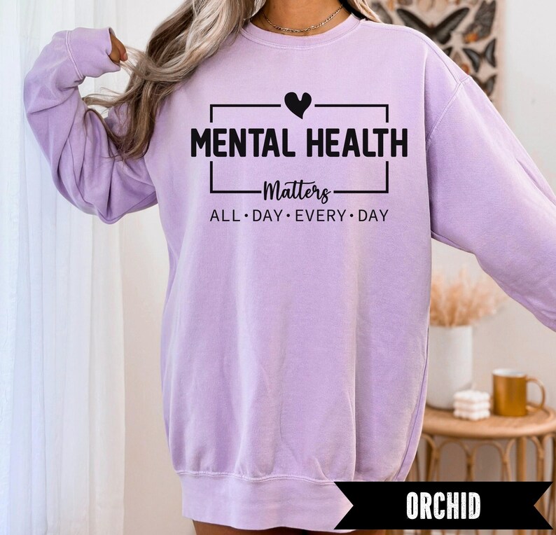 Peut inclure: Un sweat-shirt lilas avec l'inscription "MENTAL HEALTH Matters" en noir. Les mots "ALL DAY EVERY DAY" sont en dessous. Le sweat-shirt &agrave; manches longues est de couleur unie. Le mot "ORCHID" est affich&eacute; en bas de l'image.