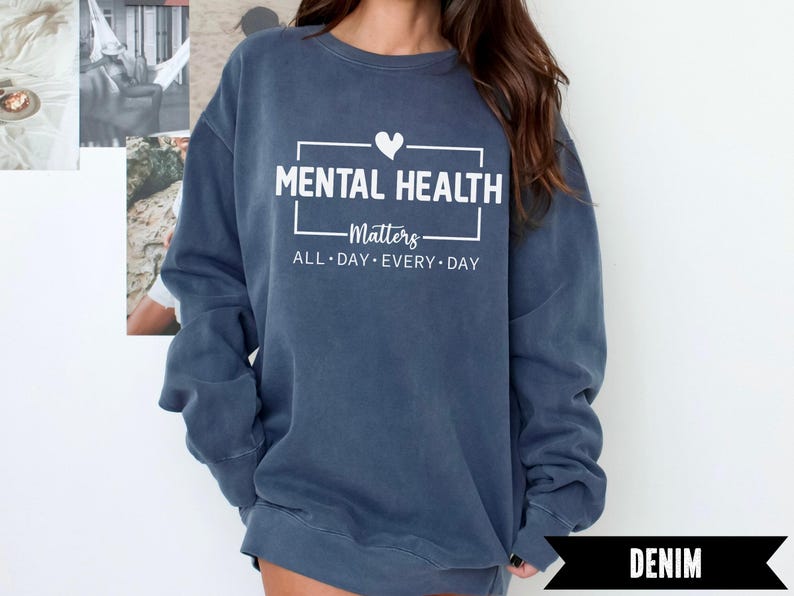 Peut inclure: Sweat-shirt bleu denim avec l'inscription blanche "MENTAL HEALTH Matters ALL DAY EVERY DAY" et un symbole de c&oelig;ur. Le sweat-shirt est de coupe d&eacute;contract&eacute;e.