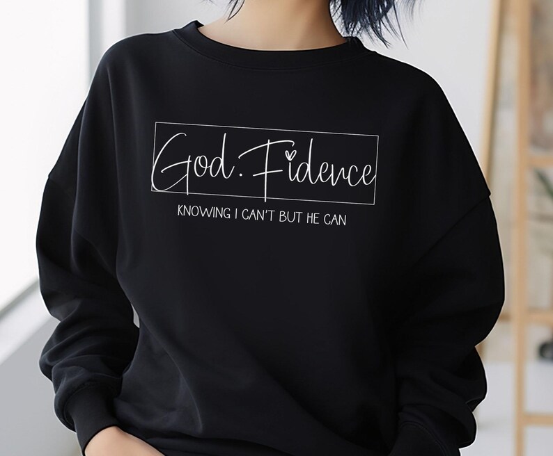 以下が含まれることがあります： 「God. Fidence」と「Knowing I can't but He can」という白い文字が書かれた黒いスウェットシャツ。