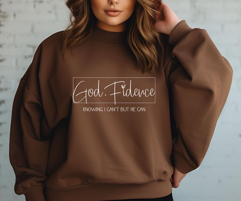 以下が含まれることがあります： 「God. Fidence」と「Knowing I can't but He can」という文字が書かれた茶色のスウェットシャツです。