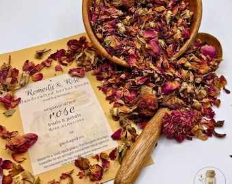 May include: A wooden bowl and spoon overflowing with dried rose buds and petals. A kraft paper package with the text "Remedy & Rise" and "organic dried rose" is visible. The image showcases a natural, botanical theme.