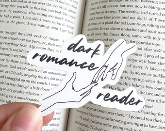 May include: A white sticker with a black outline of two hands holding each other. The sticker has the text "dark romance reader" written in black.