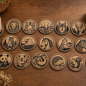 May include: A collection of seventeen circular wooden coasters, each featuring a distinct laser-engraved animal illustration. The set includes depictions of a lion, tiger, elephant, wolf, deer, fox, owl, eagle, horse, giraffe, zebra, panda, koala, sloth, hedgehog, squirrel, and chipmunk.