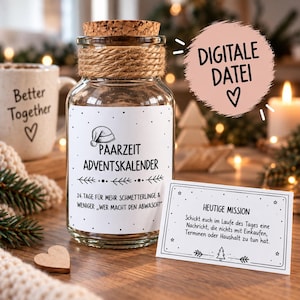 Peut inclure: Un bocal en verre transparent avec un bouchon en liège et de la ficelle autour du goulot. L'étiquette indique "PAARZEIT ADVENTSKALENDER" avec un bonnet de Père Noël. Une carte rectangulaire affiche "HEUTIGE MISSION". Un cercle rose indique "DIGITALE DATEI".