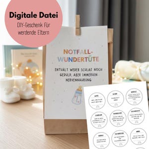 Pode incluir: Uma sacola de presente de papel marrom com um cartão branco preso, com o texto "NOTFALL-WUNDERTÜTE" e uma ilustração de mamadeira. O cartão também tem texto em alemão. Etiquetas redondas adicionais com texto em alemão são visíveis.