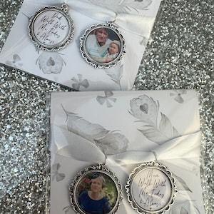 May include: Two silver-toned photo charms with white ribbon. The charms feature a photo of a woman and child, and the text "Dad Walk With Me Today & Always" and "Mom Walk With Me Today & Always".