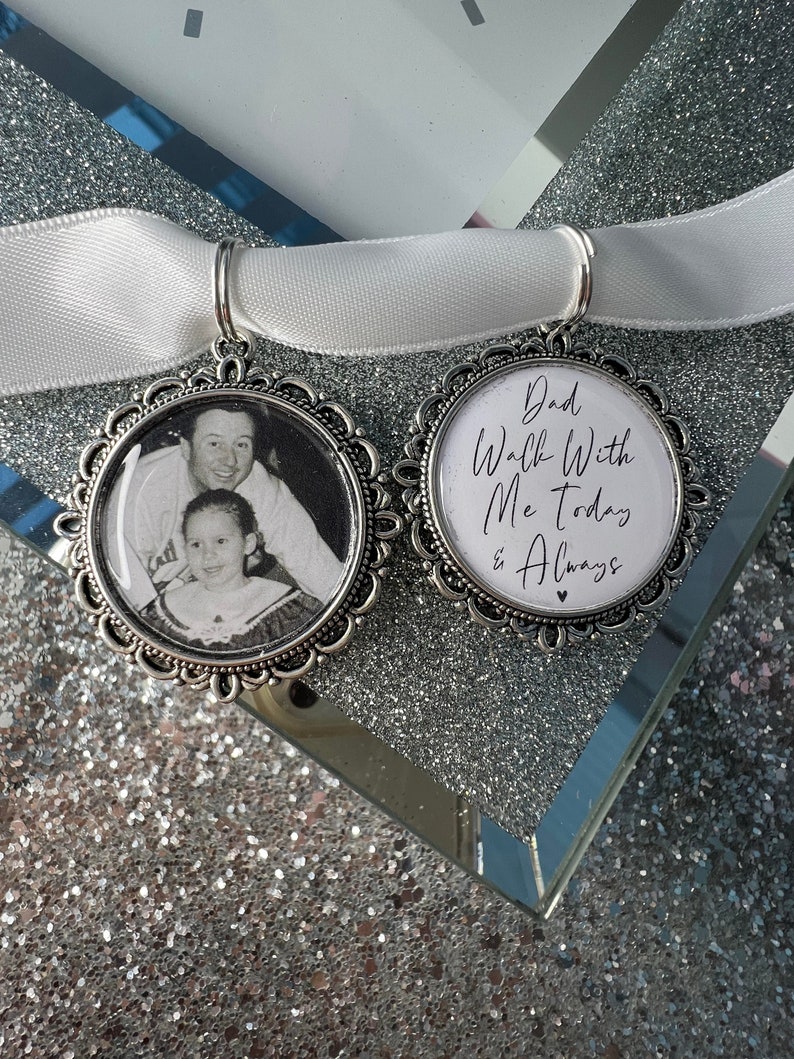 May include: Two silver charm pendants with white ribbon. One pendant features a photo of a father and daughter. The other pendant has the text "Dad Walk With Me Today & Always" with a small heart.
