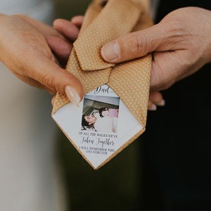 May include: A yellow patterned tie with a white card attached to it. The card has a photo of a father and daughter and the text "Dad, Of all the walks we've taken together, I will remember this one forever."