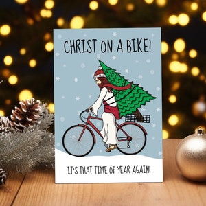 Divertida tarjeta navideña, Cristo en bicicleta. Ya es Navidad otra vez. Tarjeta de felicitación de diciembre. Tamaño: 7 x 5 pulgadas o A5 grande.