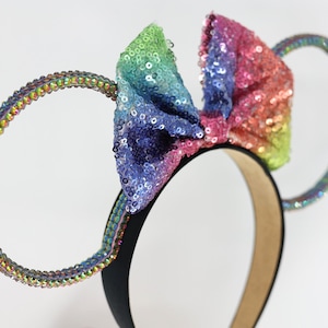 May include: Rainbow sequined bow headband with iridescent jeweled ears.
