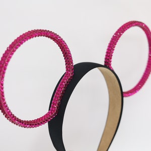 May include: Pink rhinestone headband with two large, round, pink rhinestone ears.