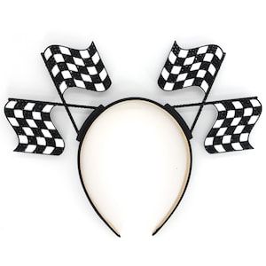 May include: A black headband with four black and white checkered flags attached. The flags are attached to the headband with black wire.
