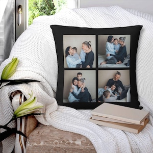 K&ouml;nnte beinhalten: Ein schwarzes Kissen mit einer Collage aus vier Fotos einer Familie. Die Fotos sind in einem Raster angeordnet und zeigen die Familienmitglieder in verschiedenen Posen. Das Kissen liegt auf einer wei&szlig;en Decke.