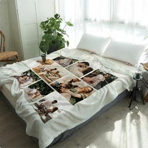 Może przedstawiać: Biały polarowy koc z kolażem zdjęć rodzinnych. Zdjęcia ułożone są we wzór siatki na kocu. Koc leży na łóżku z białymi poduszkami i szarą spódnicą łóżka. Roślina i stolik nocny znajdują się w tle.