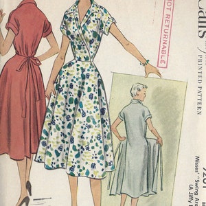 May include: Vintage sewing pattern for a women's dress. The pattern is for a swing around dress, also known as a jiffy dress. The pattern is from 1953 and is for sizes 34 to 35c bust. The pattern is printed on a white background with black text. The text on the pattern says "McCall's Printed Pattern", "R63", "1953", "Not Returnable", "Misses' "Swing Around" (A Jiffy Dress)", "Bust 34 35c".