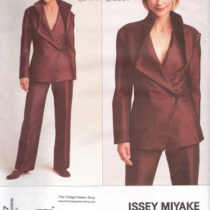 Puede incluir: Un patrón original de diseñador Vogue de Issey Miyake, circa 2002, que presenta un traje burdeos con un diseño de blazer asimétrico único y pantalones a juego. El número de patrón es 2687, tallas 12, 14, 16.