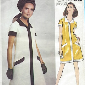 May include: A vintage sewing pattern for a dress, Vogue Americana 1165, late 1960s. The pattern features two styles of a short-sleeved dress, one white with black trim and the other yellow with white trim. The pattern is by Oscar de la Renta.