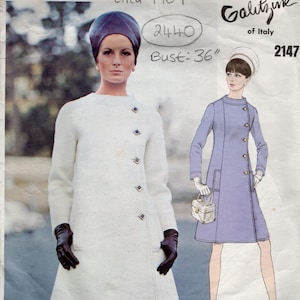 Könnte beinhalten: Vintage Vogue Couturier Design Schnittmuster von 1969. Das Schnittmuster zeigt eine Frau in einem weißen Mantel mit dunklen Handschuhen und passendem Hut. Brustumfang: 91 cm. Das Galitzine of Italy Design hat die Nummer 2147.