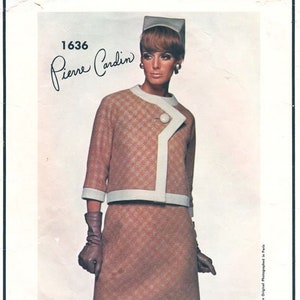 May include: A vintage Vogue Paris Original sewing pattern featuring a design by Pierre Cardin. The pattern number is 1636. The model is wearing a brown and white checkered jacket and skirt set with a white collar and a white trim. The model is also wearing a white hat.