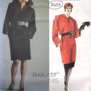 Puede incluir: Patrón de costura Vogue Patterns Paris Original con un abrigo negro con capucha y cinturón y un abrigo rojo con capucha y cinturón. El patrón incluye una medida de busto de 96,5 cm. El logotipo de Yves Saint Laurent es visible.