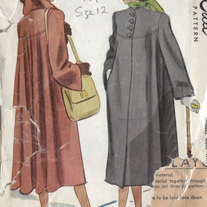 Puede incluir: Patrón de costura vintage para un abrigo de mujer. El patrón es de 1947 y es para la talla 12. El patrón muestra a dos mujeres usando el abrigo, una con un abrigo marrón y la otra con un abrigo gris. El patrón está impreso en papel y tiene un aspecto vintage.