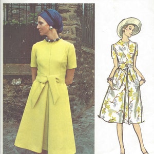 May include: A vintage Vogue Couturier Design sewing pattern for a dress. The pattern is for a yellow dress with a bow at the waist and a floral print dress. The pattern number is 2509 and the designer is Sybil Connolly.