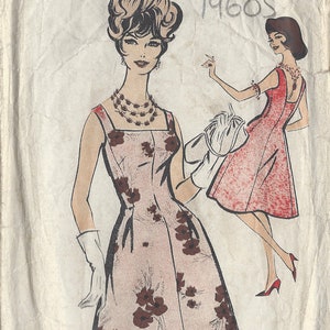 Op de afbeelding: Vintage naaipatroon voor een jurk, met een ontwerp uit de jaren 1960. Het patroon is getiteld "Blackmore So-Easy" en bevat instructies voor maat 16, 36 borstomvang. Het patroon toont een vrouw die een roze jurk draagt met een bruine bloemenprint en een witte handschoen.