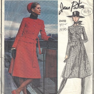 May include: Vintage Vogue Paris Original sewing pattern featuring two designs by Jean Patou. The first design is a red coat with a belt and the second design is a black and white chevron print coat with a belt. The pattern number is 2410 and the year is 1970.