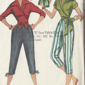 Puede incluir: Un patrón de costura vintage que presenta dos blusas para mujer con mangas cortas y estilo de envoltura. La blusa de la izquierda es roja con lunares blancos y la blusa de la derecha es verde con rayas blancas. Ambas blusas tienen un lazo en la cintura. El patrón es de 'N' Save Fabric Shop, Shopping Ctr. 532 No. Michigan.