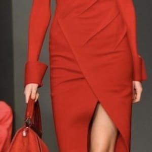 Pode incluir: Vestido vermelho com decote em V e mangas compridas. O vestido tem uma saia envelope com uma fenda alta. Uma bolsa vermelha a condizer e um chapéu preto completam o look. A modelo usa saltos vermelhos.