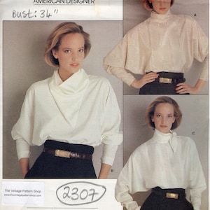 Könnte beinhalten: Vogue Patterns Schnittmuster für eine weiße Bluse mit hohem Kragen und langen Ärmeln. Das Schnittmuster ist für ein Design von Perry Ellis aus dem Jahr 1983. Die Schnittmuster-Nummer ist 2307 und die Muster-/Patronennummer ist 1227.