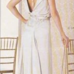 Może przedstawiać: Biała, bezrękawowa suknia z odkrytymi plecami i drapowanym dekoltem. Suknia wykonana jest z miękkiej, płynnej tkaniny i ma prosty, elegancki design.