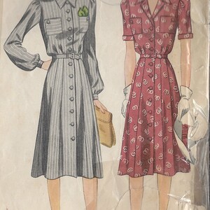 Puede incluir: Patrón de costura vintage para dos vestidos. El primer vestido es un vestido a rayas con botones y cinturón. El segundo vestido es un vestido de estampado floral rojo y blanco con botones en el frente. Ambos vestidos tienen mangas cortas y son hasta la rodilla.