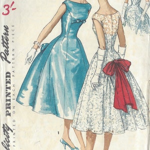 Peut inclure: Patron de couture vintage pour deux robes. La première robe est bleu clair, sans manches, avec un corsage ajusté et une jupe ample. La deuxième robe est blanche avec un motif floral et un nœud rouge à l'arrière. Le patron est pour la taille 14, tour de poitrine 86 cm, tour de hanches 91 cm.