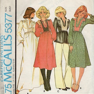 May include: Vintage sewing pattern McCall's 5377 for a misses' and junior dress or top. The pattern is from circa 1976 and features three different styles of dresses, one with a white floral print, one with a red print, and one with a green floral print.