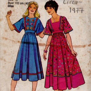 May include: Vintage sewing pattern showing two dresses. One is blue with floral details, the other is pink with a floral print. The pattern is labelled "1943" and "Style", with a bust size of 102 cm.