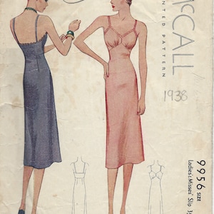 Op de afbeelding: Vintage McCall's naaipatroon voor een slipjurk, maat 16, dames en meisjes, 89 cm. Het patroon is gedrukt op papier en toont twee vrouwen die de slipjurk dragen, een in een donkerblauwe slip en de andere in een lichtroze slip.