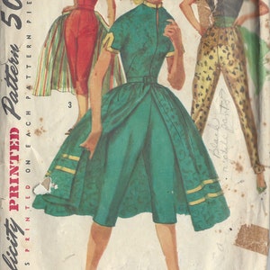 Peut inclure: Patron de couture vintage pour une robe verte avec un col blanc et des finitions dorées. Le patron est imprimé sur un fond blanc avec du texte noir qui indique "Simplicity PRINTED Pattern 50c".