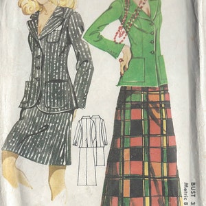 May include: Vintage sewing pattern featuring illustrations of two women in 1970s fashion. One model wears a pinstripe suit with a hat, the other a green jacket and plaid skirt. The pattern includes bust sizes 32.5" to 38".