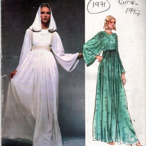 May include: Vintage Vogue Paris Original sewing pattern for a long white dress with a hood and a long green dress with a gathered waist. The pattern is from 1971 and is for size 1553.