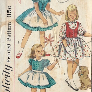 May include: Vintage Simplicity sewing pattern for a girl's dress. The pattern is for size 3 and is printed on a white background with a red and blue border. The pattern shows three girls wearing different styles of dresses. The pattern number is 1979 and the year is 1957.