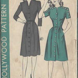 Peut inclure: Patron de couture vintage pour une robe, avec deux illustrations de femmes portant la robe. Le numéro du patron est R481 et la taille est 12. La robe de gauche est à rayures noires et blanches, tandis que la robe de droite est turquoise.