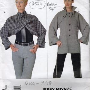 May include: A Vogue Patterns sewing pattern envelope for Issey Miyake design 2524, featuring two jacket styles. View B is a black and white checkered cropped jacket with a high collar. View A is a grey textured jacket with buttons and a collar.