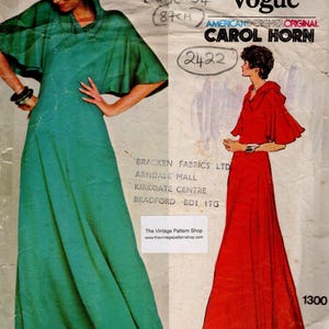 May include: A vintage Vogue sewing pattern from 1976, showcasing two hooded maxi dresses. One dress is teal, the other is red. The pattern, designed by Carol Horn, is for a 34-inch (87cm) bust.