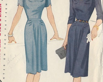 May include: Vintage sewing pattern for a dress with a simple to make design. The pattern is for size 14 and 32 bust. The pattern shows two women wearing the dress in blue and navy.