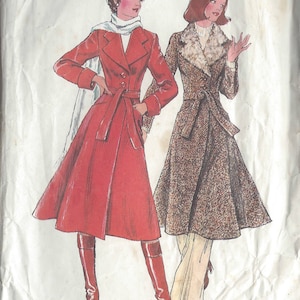 May include: A vintage sewing pattern for two coats. The pattern is for size 14, bust 92 cm. The first coat is red with a white scarf and the second coat is brown with a faux fur collar. Both coats have a belt and are knee-length.